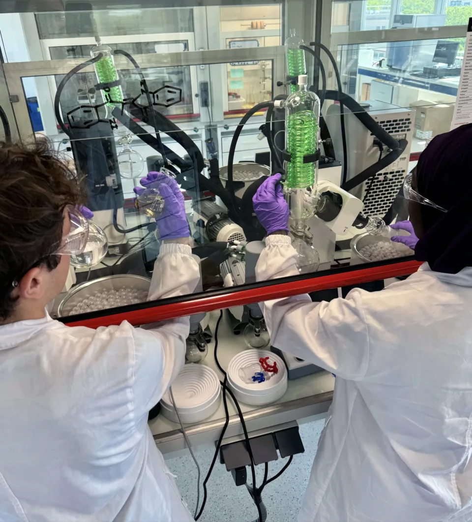 2 chimistes devant une hotte manipulant des produits dans les laboratoires de Pili